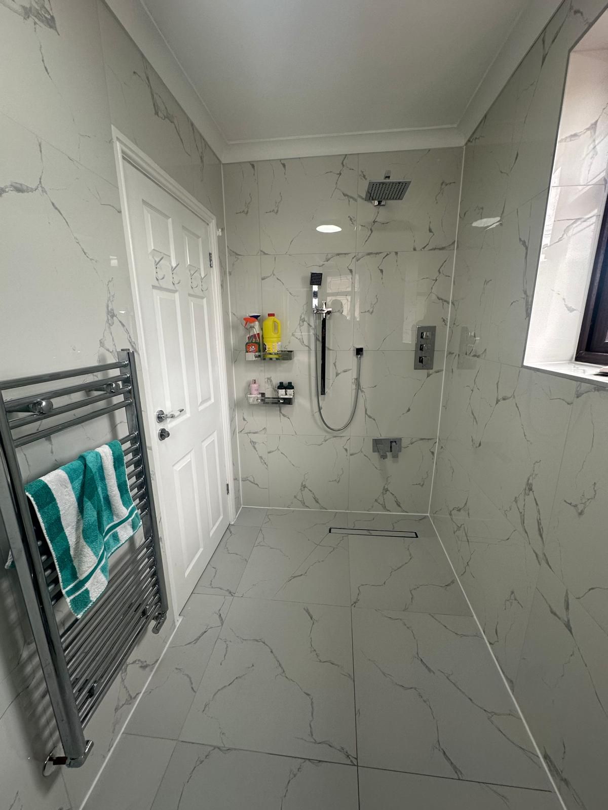 Grey marble-effect wet room bathroom renovated by JFA Construction Group