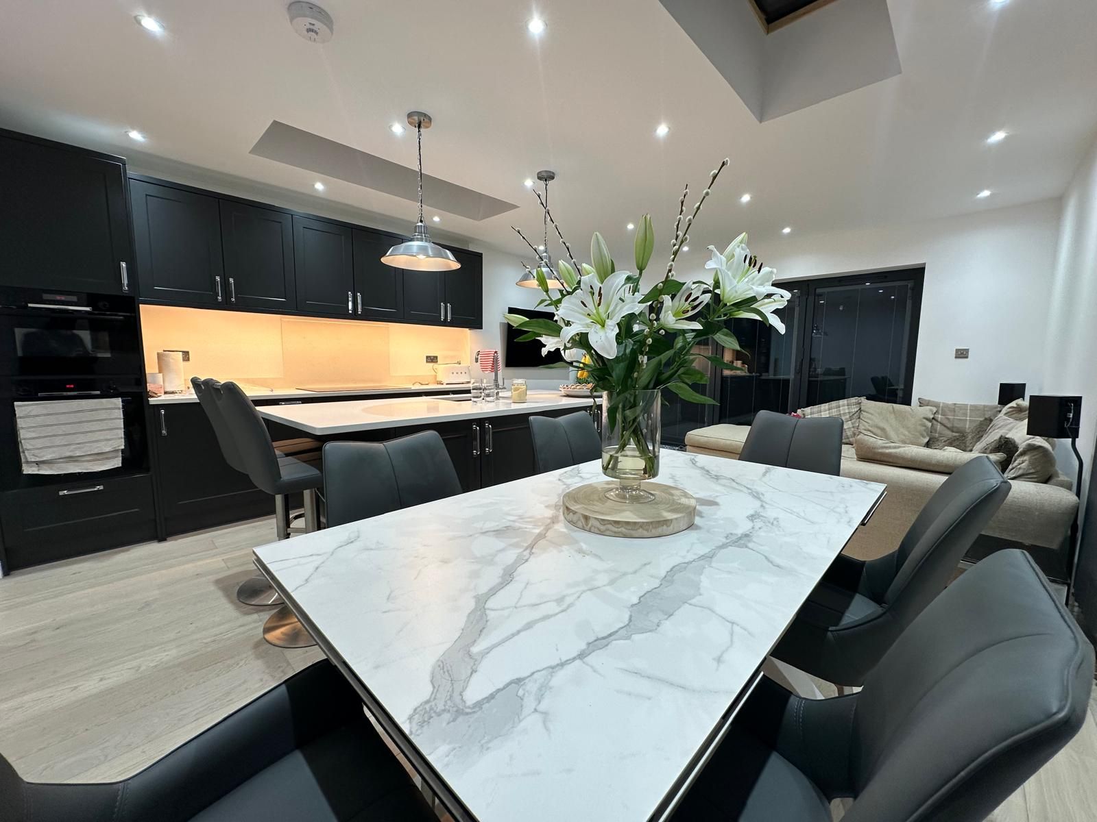 Renovated kitchen with a marble dining table by JFA Construction Group