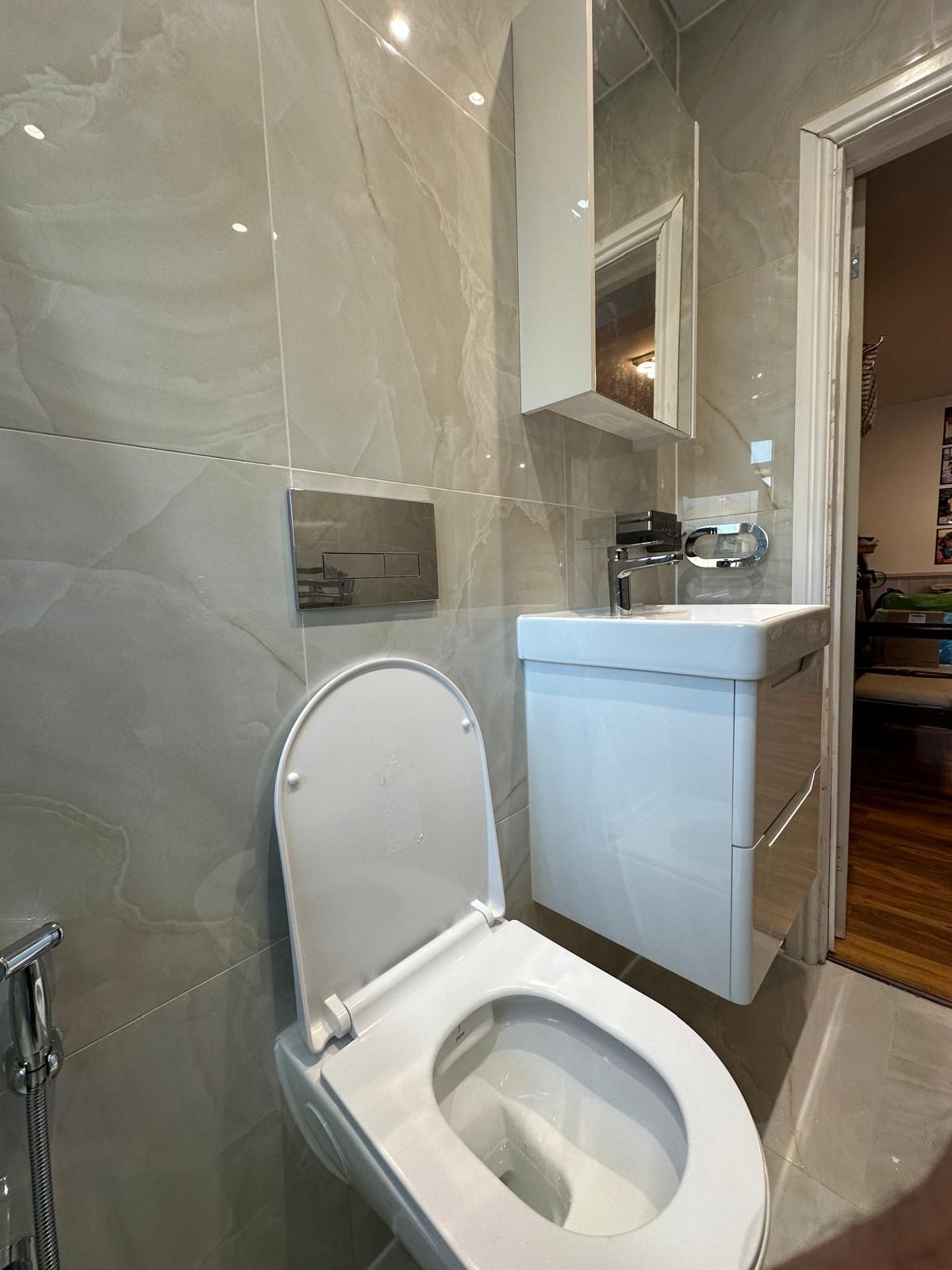 Marble-effect bathroom suite renovated by JFA Construction Group in Highams Park